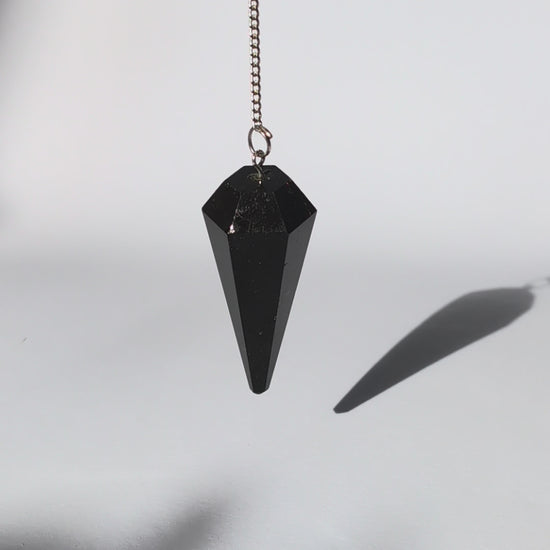 Schwarzes Turmalin Pendel mit facettierter Spitze und versilberter Kette.