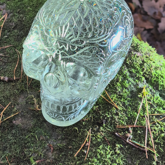 Monumentaler 6.4kg Kristallschädel "Hekate" aus gelbem Obsidian mit vollflächiger Handgravur, auf Moos im Wald liegend.