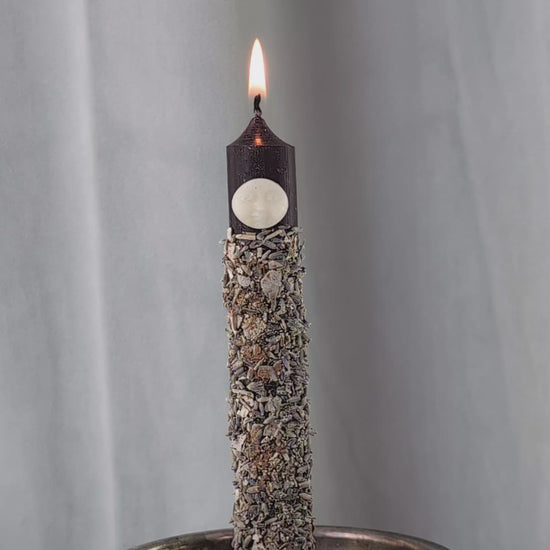 Handgegossene Vollmond Ritualkerze "Lunar Abundance" mit Kräutern in einem Glasgefäß.