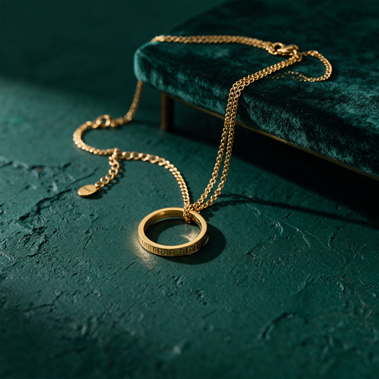 Kette mit Ring vergoldet | Gravur „Be Here Right Now“ für Achtsamkeit – Produktansicht vor tiefem Smaragdgrün