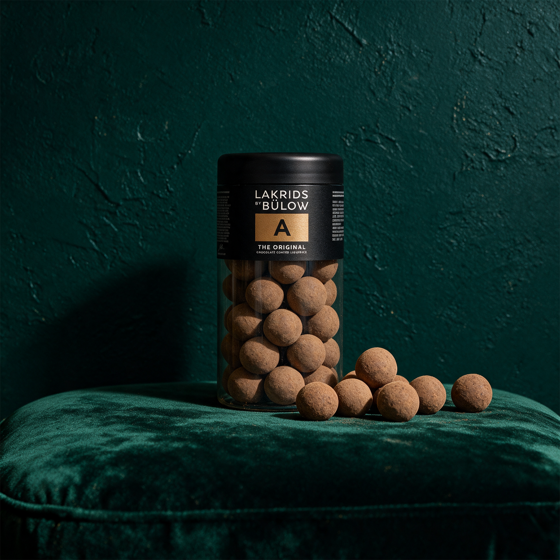LAKRIDS by Bülow The Original | Lakritz in Milchschokolade – Produktansicht vor tiefem Smaragdgrün