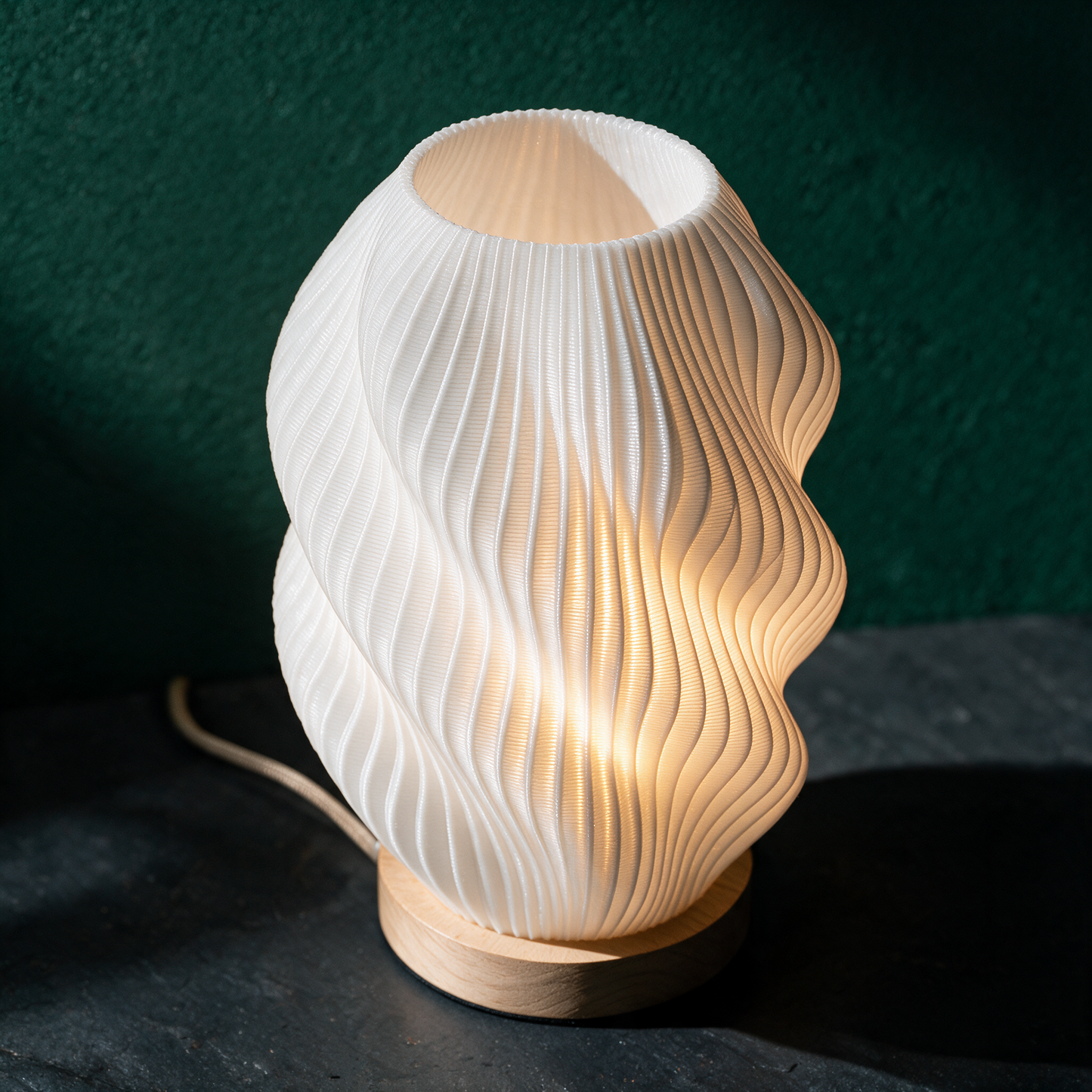 Twuro Tischlampe | Wellen-Lichtkörper für warme Atmosphäre – Material- und Detailansicht in der smaragdgrünen Temple-of-Desire-Bildwelt
