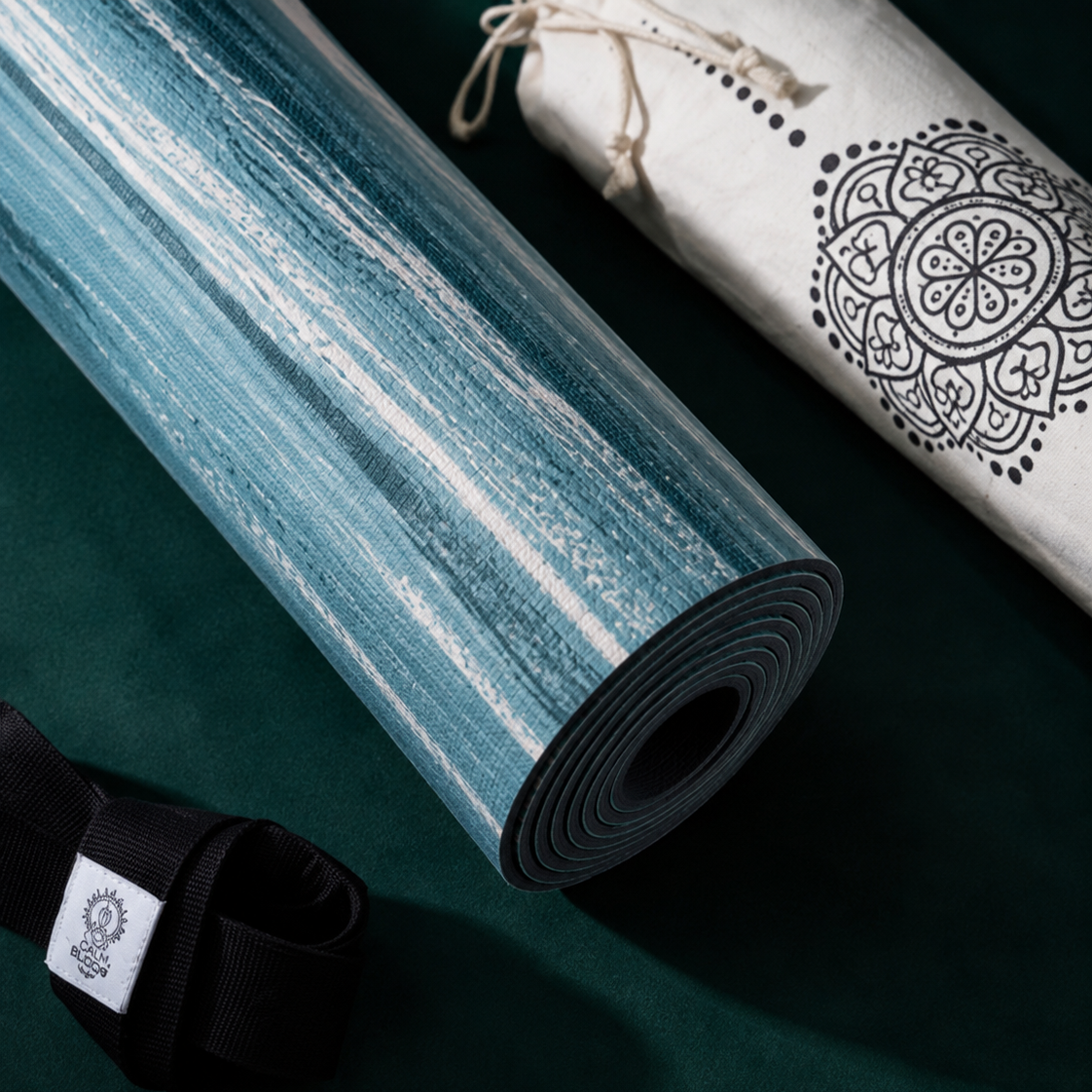 Detailaufnahme der Yogamatte PURE von Divasya-Yoga mit blau-türkiser Marmorierung, schwarzem Gurt und weißer bedruckter Hülle